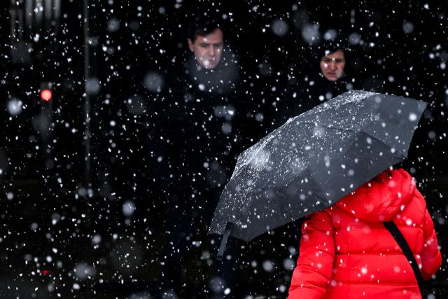 A woman with an umbrella enters an underground passage in Frankfurt am Main, western Germany, on January 26, 2026 as the air temperature reached 1 degrees Celsius above zero. (Photo by Kirill KUDRYAVTSEV / AFP)