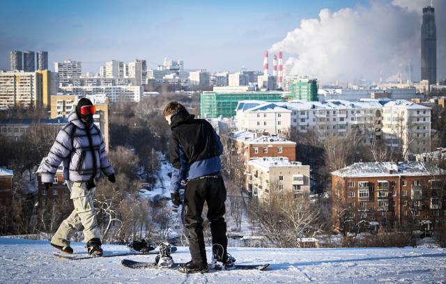 Snowboarders prepare to slide down a slope at the Kant Ski Club in southern Moscow on January 26, 2026. (Photo by Alexander NEMENOV / AFP)