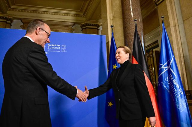German Chancellor Friedrich Merz greets Denmark's Prime Minister Mette Frederiksen during the North Sea Summit on January 26, 2026 at the City Hall of in Hamburg, northern Germany. European leaders meet to discuss North Sea energy and security cooperation, but fears over US designs on the Arctic island of Greenland may overshadow the talks. The region has long worried about threats posed by Russia -- but more recently tensions have surged over US President Donald Trump's push for the autonomous territory of Denmark. (Photo by Tobias SCHWARZ / AFP)
