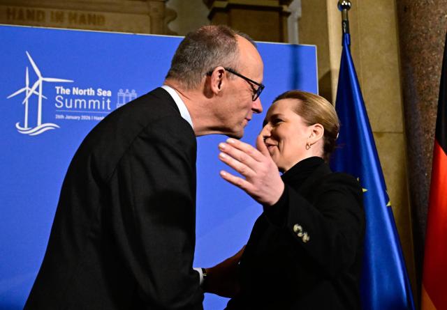 German Chancellor Friedrich Merz greets Denmark's Prime Minister Mette Frederiksen during the North Sea Summit on January 26, 2026 at the City Hall of in Hamburg, northern Germany. European leaders meet to discuss North Sea energy and security cooperation, but fears over US designs on the Arctic island of Greenland may overshadow the talks. The region has long worried about threats posed by Russia -- but more recently tensions have surged over US President Donald Trump's push for the autonomous territory of Denmark. (Photo by Tobias SCHWARZ / AFP)