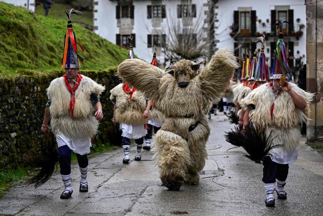 A participant dressed up as a 'Hartza' (bear) (C) parades with bellringers, known as "Joaldunak" in Basque language, who march with big cowbells hanging on their backs during the traditional carnival of Ituren, in the northern Spanish province of Navarre on January 26, 2026. Locals from the neighbouring villages of Ituren and Zubieta dress up and participate in a pilgrimage through both villages in this annual three-day festival, revolving mainly around agriculture and sheep herding. (Photo by ANDER GILLENEA / AFP)