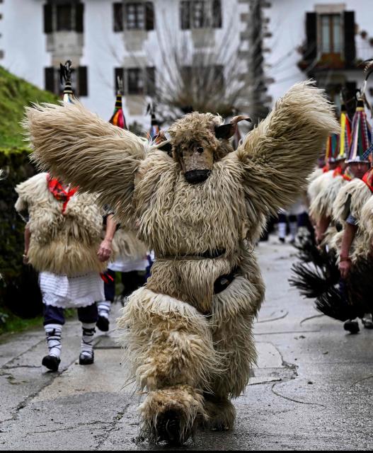 A participant dressed up as a 'Hartza' (bear) parades with bellringers, known as "Joaldunak" in Basque language, who march with big cowbells hanging on their backs during the traditional carnival of Ituren, in the northern Spanish province of Navarre on January 26, 2026. Locals from the neighbouring villages of Ituren and Zubieta dress up and participate in a pilgrimage through both villages in this annual three-day festival, revolving mainly around agriculture and sheep herding. (Photo by ANDER GILLENEA / AFP)