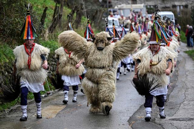 A participant dressed up as a 'Hartza' (bear) (C) parades with bellringers, known as "Joaldunak" in Basque language, who march with big cowbells hanging on their backs during the traditional carnival of Ituren, in the northern Spanish province of Navarre on January 26, 2026. Locals from the neighbouring villages of Ituren and Zubieta dress up and participate in a pilgrimage through both villages in this annual three-day festival, revolving mainly around agriculture and sheep herding. (Photo by ANDER GILLENEA / AFP)