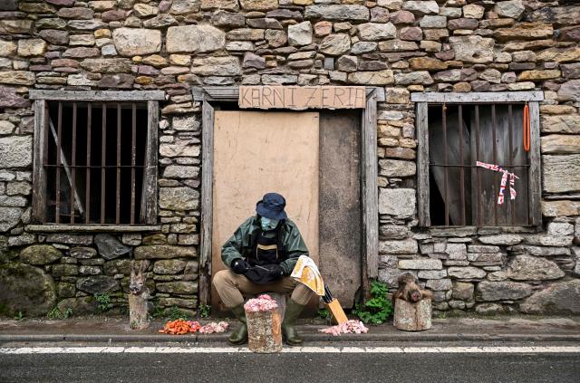A masked reveller takes part in the traditional carnival of Ituren dressed up as a butcher in the northern Spanish province of Navarre on January 26, 2026. Locals from the neighbouring villages of Ituren and Zubieta dress up and participate in a pilgrimage through both villages in this annual three-day festival, revolving mainly around agriculture and sheep herding. (Photo by ANDER GILLENEA / AFP)