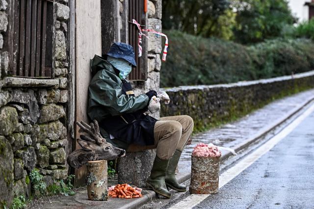 A masked reveller takes part in the traditional carnival of Ituren dressed up as a butcher in the northern Spanish province of Navarre on January 26, 2026. Locals from the neighbouring villages of Ituren and Zubieta dress up and participate in a pilgrimage through both villages in this annual three-day festival, revolving mainly around agriculture and sheep herding. (Photo by ANDER GILLENEA / AFP)