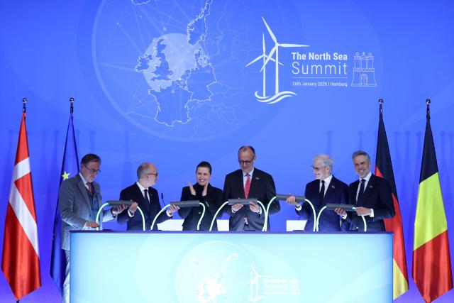 Belgium's Prime Minister Bart de Wever, Luxemburg's Prime Minister Luc Frieden, Denmark's Prime Minister Mette Frederiksen, German Chancellor Friedrich Merz, Norway's Prime Minister Jonas Gahr Store and Netherland's Prime Minister Dick Schoof hold a light cable after signing the Hamburg declaration during the North Sea Summit on January 26, 2026 at the City Hall of Hamburg, northern Germany. European leaders meet to discuss North Sea energy and security cooperation, but fears over US designs on the Arctic island of Greenland may overshadow the talks. The region has long worried about threats posed by Russia -- but more recently tensions have surged over US President Donald Trump's push for the autonomous territory of Denmark. (Photo by Ronny HARTMANN / AFP)