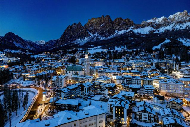 This aerial view shows the Olympic host city of Cortina d'Ampezzo, northern Italy as the sun sets behind the mountains prior to the Milano Cortina 2026 Olympic Games, on January 26, 2026. (Photo by Odd ANDERSEN / AFP)