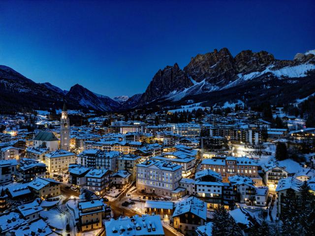 This aerial view shows the Olympic host city of Cortina d'Ampezzo, northern Italy as the sun sets behind the mountains prior to the Milano Cortina 2026 Olympic Games, on January 26, 2026. (Photo by Odd ANDERSEN / AFP)