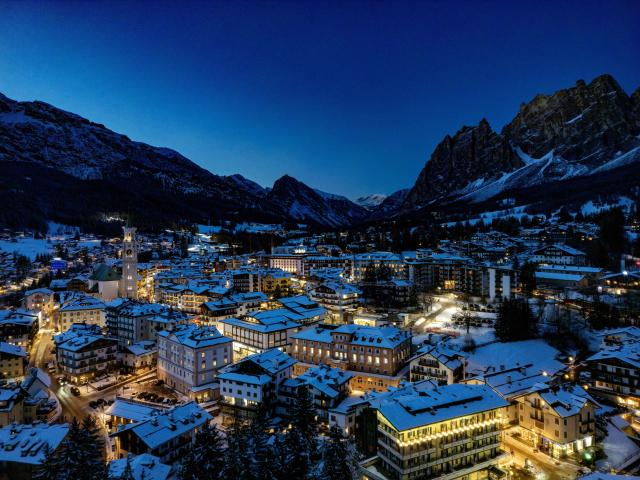 This aerial view showing the Olympic host city of Cortina d'Ampezzo, northern Italy as the sun sets behind the mountains prior to the Milano Cortina 2026 Olympic Games, on January 26, 2026. (Photo by Odd ANDERSEN / AFP)