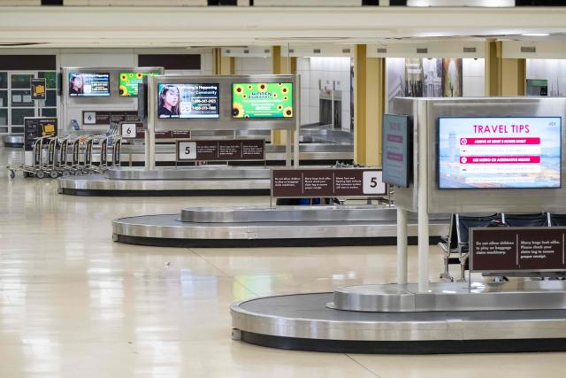 An empty baggage claim area is seen as flights are delayed and cancelled following a significant winter storm at Ronald Reagan Washington National Airport in Arlington, Virginia, January 26, 2026. Millions of Americans were facing dangerously cold temperatures in the wake of a massive winter storm that whipped snow and ice across the country, knocking out power and paralyzing transportation. A frigid, potentially life-threatening Arctic air mass threatened to delay clean-up as municipalities from New Mexico to Maine tried to dig out following the storm, which dropped a vicious cocktail of heavy snow and wind along with freezing rain and sleet. (Photo by SAUL LOEB / AFP)