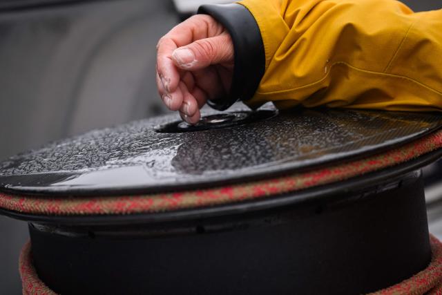 This photograph shows the hand of French skipper Alexia Barrier as she and her crew sail towards the Brest harbour on the Ultim multihull Idec Sport after crossing the finish line of the Jules Verne Trophy, off the coast of Brest, Brittany, on January 26, 2026. French skipper Alexia Barrier (The Famous Project) and her six crew members completed on January 26, 2026, off the coast of Brest, the first non-stop round-the-world voyage in a maxi-trimaran with an all-female crew, her team announced. The Jules Verne Trophy is a prize for the fastest crewed, unassisted and non-stop circumnavigation of the world on any type of yacht. (Photo by Loic VENANCE / AFP)