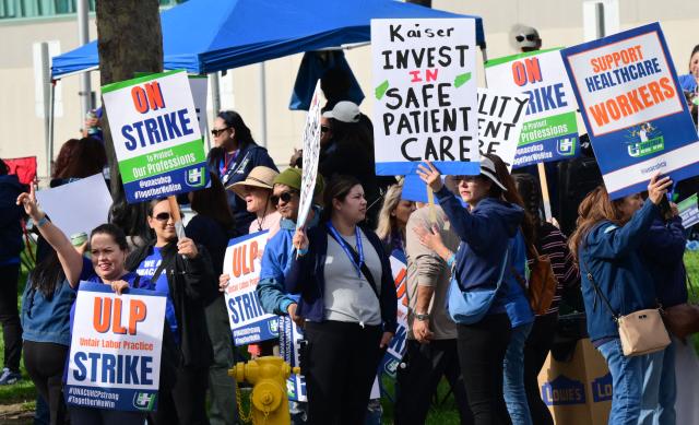 Nurses and healthcare professionals demonstrate during a strike against Kaiser Permanente outside one of their medical facilities in Los Angeles, California, on January 26, 2026. More than 31,000 registered nurses and healthcare professionals represented by the United Nurses Associations of California and the Union of Health Care Professionals began a strike against Kaiser Permanente in California and Hawaii, pushing for increased staffing levels and wage boosts. (Photo by Frederic J. BROWN / AFP)