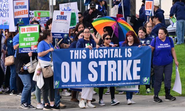 Nurses and healthcare professionals demonstrate during a strike against Kaiser Permanente outside one of their medical facilities in Los Angeles, California, on January 26, 2026. More than 31,000 registered nurses and healthcare professionals represented by the United Nurses Associations of California and the Union of Health Care Professionals began a strike against Kaiser Permanente in California and Hawaii, pushing for increased staffing levels and wage boosts. (Photo by Frederic J. BROWN / AFP)