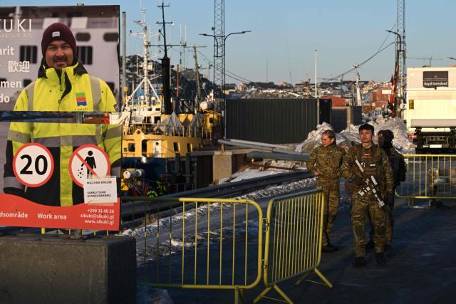 Danish soldiers stand at a checkpoint in the harbor of Nuuk, Greenland, on January 26, 2026. HDMS Knud Rasmussen (P570) and HDMS Ejnar Mikkelsen (P571), Royal Danish Navy patrol vessels, are moored in the harbour. They are employed to exercise Danish sovereignty in the waters around the Faroe Islands and Greenland. (Photo by Ina FASSBENDER / AFP)