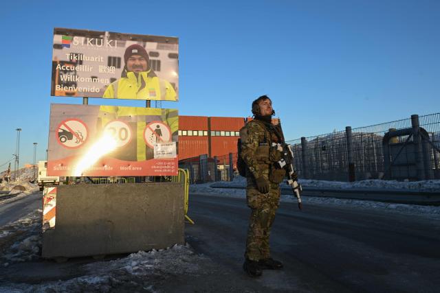 A Danish soldier stands at a checkpoint in the harbor of Nuuk, Greenland, on January 26, 2026. HDMS Knud Rasmussen (P570) and HDMS Ejnar Mikkelsen (P571), Royal Danish Navy patrol vessels, are moored in the harbour. They are employed to exercise Danish sovereignty in the waters around the Faroe Islands and Greenland. (Photo by Ina FASSBENDER / AFP)
