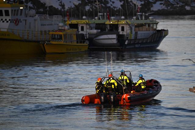 And a rubber dinghy with members of the Danish navy leaves the harbour of Nuuk, Greenland, on January 26, 2026. HDMS Knud Rasmussen (P570) and HDMS Ejnar Mikkelsen (P571), Royal Danish Navy patrol vessels, are moored in the harbour. They are employed to exercise Danish sovereignty in the waters around the Faroe Islands and Greenland. (Photo by Ina FASSBENDER / AFP)