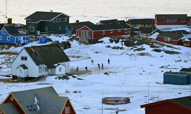 Children playing football in a snowy residential area in the city of Nuuk, western Greenland, on January 26, 2026. (Photo by Ina FASSBENDER / AFP)
