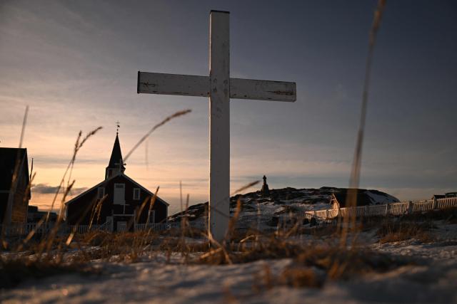 A cross can be seen in a cemetery near a church in the city of Nuuk, western Greenland, on January 26, 2026. (Photo by Ina FASSBENDER / AFP)