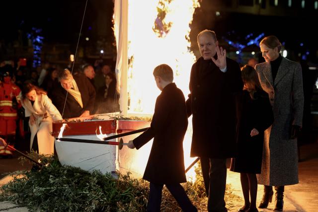 Prince Albert II of Monaco (C), Princess Charlene (R) and their children Prince Jacques (L) and Princess Gabriella, use torches to light tree branches displayed underneath a sailbot during the traditional celebration of Sainte-Devote in the Principality of Monaco on January 26, 2026. (Photo by Valery HACHE / AFP) / / NO TABLOIDS WEB & PRINT, NO DAILY MAIL, NO DAILY MAIL GROUP, NO VOICI, NO CLOSER