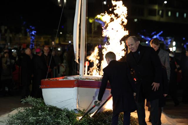 Prince Albert II of Monaco (C), Princess Charlene (R) and their children Prince Jacques (L) and Princess Gabriella, use torches to light tree branches displayed underneath a sailbot during the traditional celebration of Sainte-Devote in the Principality of Monaco on January 26, 2026. (Photo by Valery HACHE / AFP) / / NO TABLOIDS WEB & PRINT, NO DAILY MAIL, NO DAILY MAIL GROUP, NO VOICI, NO CLOSER