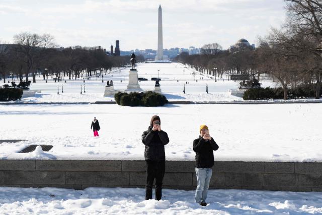 People take photographs outside the US Capitol on Capitol Hill in Washington, DC, January 26, 2026. Millions of Americans were facing dangerously cold temperatures in the wake of a massive winter storm that whipped snow and ice across the country, knocking out power and paralyzing transportation. A frigid, potentially life-threatening Arctic air mass threatened to delay clean-up as municipalities from New Mexico to Maine tried to dig out following the storm, which dropped a vicious cocktail of heavy snow and wind along with freezing rain and sleet. (Photo by SAUL LOEB / AFP)
