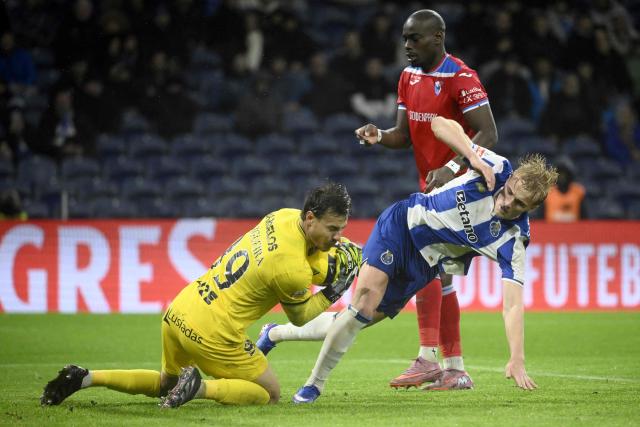 FC Porto's Danish midfielder #08 Victor Froholdt falls as he challenges Gil Vicente's Portuguese goalkeeper #99 Daniel Figueira during the Portuguese League football match between FC Porto and Gil Vicente FC at Dragao stadium in Porto, on January 26, 2026. (Photo by Miguel RIOPA / AFP)