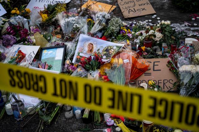 Photos of Nicole Good (L) and Alex Pretti are placed among flowers at a makeshift memorial in the area where Pretti was shot and killed by Federal immigration agents in Minneapolis, Minnesota, on January 26, 2026. On January 24, federal agents shot and killed Alex Pretti, a 37-year-old ICU nurse, while scuffling with him on an icy roadway in Minneapolis, less than three weeks after an immigration officer fired on Renee Good, also 37, killing her in her car. US President Donald Trump blamed their deaths on Democratic "chaos," as his administration faced intensifying pressure over its mass immigration crackdown in Minneapolis. (Photo by ROBERTO SCHMIDT / AFP)
