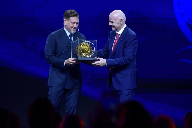 FIFA President Gianni Infantino (R) gives a prize to CONMEBOL President Alejandro Dominguez (L) during a commemorative event marking the 10th anniversary of Dominguez's work as the head of the South American Football Confederation in Luque, Paraguay on January 26, 2026. (Photo by Daniel DUARTE / AFP)