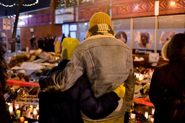 A couple mourn at a makeshift memorial in the area where Alex Pretti was shot dead by federal immigration agents in Minneapolis, Minnesota, on January 26, 2026. On January 24, federal agents shot and killed Alex Pretti, a 37-year-old ICU nurse, while scuffling with him on an icy roadway in Minneapolis, less than three weeks after an immigration officer fired on Renee Good, also 37, killing her in her car. The fatal shootings has reignited accusations that federal agents enforcing US President Donald Trump's militarized immigration crackdown are inexperienced, under-trained and operating outside law enforcement norms. (Photo by Octavio JONES / AFP)