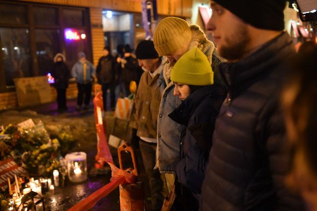 People mourn at a makeshift memorial in the area where Alex Pretti was shot dead by federal immigration agents in Minneapolis, Minnesota, on January 26, 2026. On January 24, federal agents shot and killed Alex Pretti, a 37-year-old ICU nurse, while scuffling with him on an icy roadway in Minneapolis, less than three weeks after an immigration officer fired on Renee Good, also 37, killing her in her car. The fatal shootings has reignited accusations that federal agents enforcing US President Donald Trump's militarized immigration crackdown are inexperienced, under-trained and operating outside law enforcement norms. (Photo by Octavio JONES / AFP)