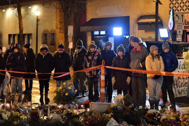People mourn at a makeshift memorial in the area where Alex Pretti was shot dead by federal immigration agents in Minneapolis, Minnesota, on January 26, 2026. On January 24, federal agents shot and killed Alex Pretti, a 37-year-old ICU nurse, while scuffling with him on an icy roadway in Minneapolis, less than three weeks after an immigration officer fired on Renee Good, also 37, killing her in her car. The fatal shootings has reignited accusations that federal agents enforcing US President Donald Trump's militarized immigration crackdown are inexperienced, under-trained and operating outside law enforcement norms. (Photo by Octavio JONES / AFP)