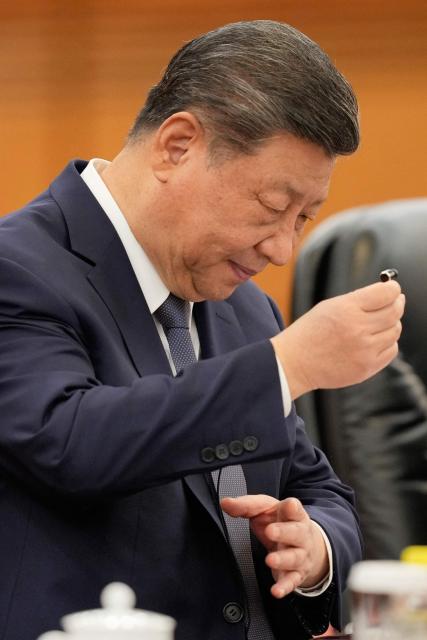 Chinese President Xi Jinping removes an earphone after listening to Finland's Prime Minister Petteri Orpo(not pictured) during their bilateral meeting at the Great Hall of the People in Beijing on January 27, 2026. (Photo by Vincent Thian / POOL / AFP)
