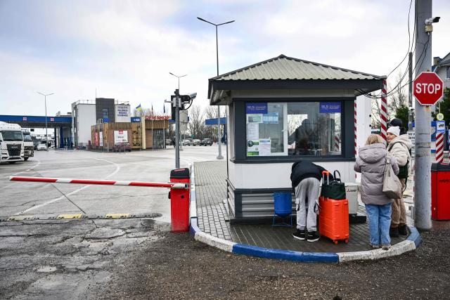 This photograph taken on January 6, 2026 shows people standing in front of the Moldova–Ukraine border crossing point of Palanca–Maiaki in the village of Palanca. Since the start of the conflict in February 2022, Moldova has recorded dozens of violations of its airspace, and several Russian missiles and drones have crashed on its territory. The latest, a Shahed drone carrying 50 kilograms of explosives, fell 12 kilometres northwest of Palenca on January 22 without causing any damage. In November, the former Soviet republic, which is neither a member of the European Union nor NATO, was forced to close its borders. (Photo by Daniel MIHAILESCU / AFP)