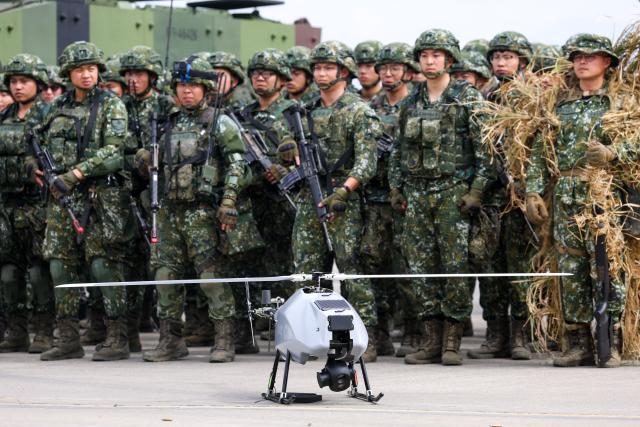 Soldiers stand next to a military unmanned Aerial Vehicle is seen in Taichung on January 27, 2026. (Photo by I-Hwa Cheng / AFP)