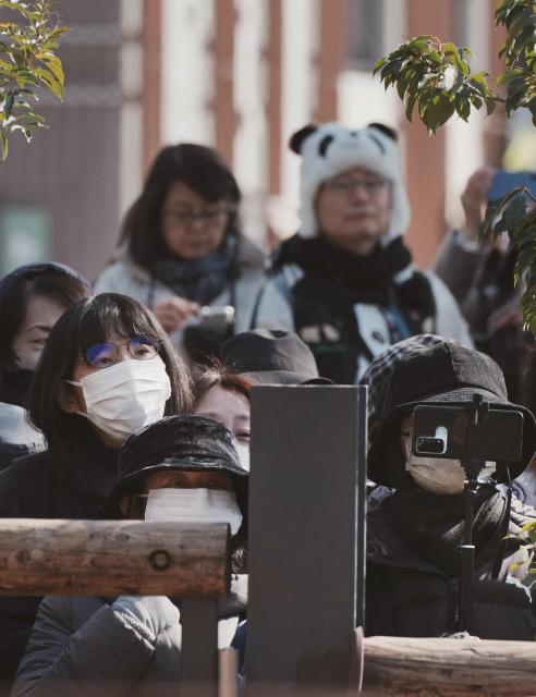 Panda lovers wait at the gates to say goodbye to the twin pandas as they depart from Ueno Zoo in Tokyo on January 27, 2026, heading towards their return to China. (Photo by Kazuhiro NOGI / AFP)