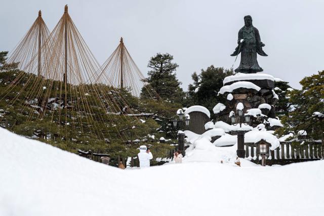 People take pictures at the snow-covered Kenroku-en garden, in Kanazawa, Ishikawa Prefecture on January 27, 2026. (Photo by Philip FONG / AFP)
