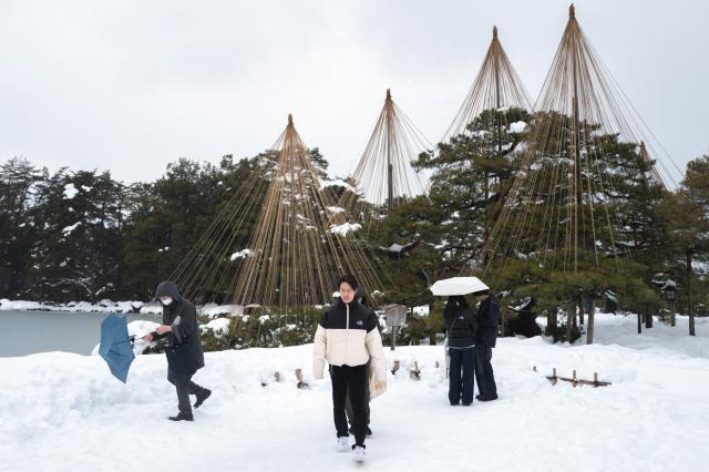 People visit the snow-covered Kenroku-en garden, in Kanazawa, Ishikawa Prefecture on January 27, 2026. (Photo by Philip FONG / AFP)
