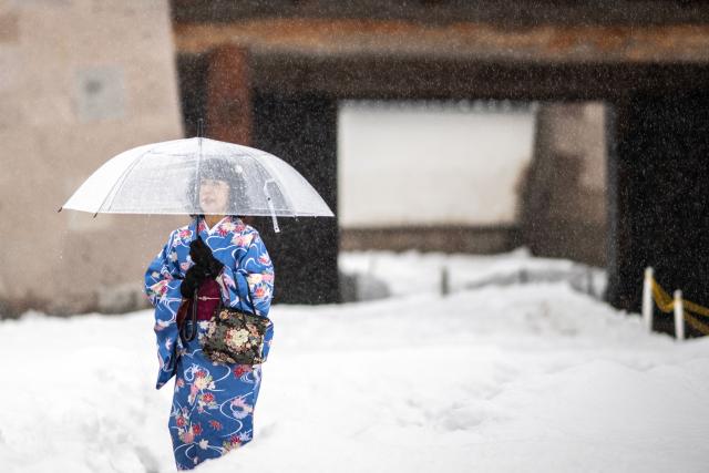 A tourist in traditional outfit visits the snow-covered Kanazawa Castle in Kanazawa, Ishikawa Prefecture on January 27, 2026. (Photo by Philip FONG / AFP)
