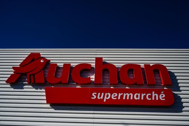 (FILES) This photograph shows the logo of French retail company Auchan on the front of a supermarket, in Beziers, southern France on March 30, 2025. Auchan intends to offer 91 supermarkets for sale to the Mousquetaires Group (Intermarche), the group announced on January 27, 2026. The struggling retailer had unveiled plans in November to convert some 300 supermarkets to Intermarche or Netto franchises, a number that has been revised downwards to 164 in the plan unveiled on January 27, 2026 in a press release. (Photo by GABRIEL BOUYS / AFP)