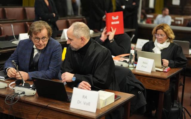 Co-defendant P (background, L) sitting next to his lawyer Gül Pinar (R) hides his face behind a red folder as in foreground are seen co-defendant Andreas Costard (L) sitting next to his lawyer Marko Voss (2nd L) waiting for the start of another session in the trial against defendant German entrepreneur and gastronome Christina Block (not in picture) over alleged child abduction at the District Court in Hamburg, northern Germany, on January 27, 2026. The public prosecutor's office accuses Block, heiress of a steakhouse chain, of ordering the abduction of her daughter, born in 2010, and her son, born in 2013. According to the indictment, the background to this is an escalating custody dispute over many years between Block and her former husband, who have four children together. (Photo by Marcus Brandt / POOL / AFP)