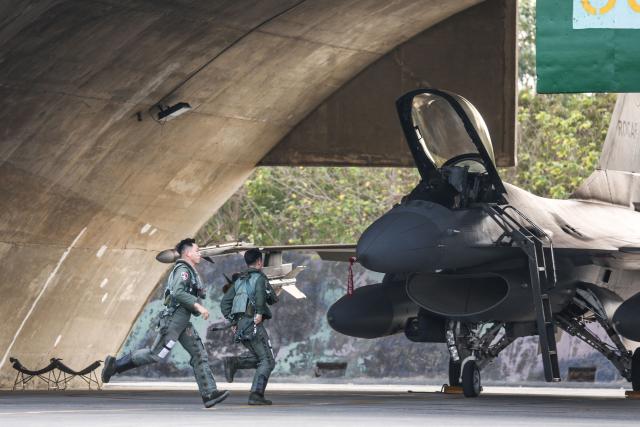 Pilots scramble to their Taiwanese air force F-16V fighter aircraft during a military exercise at Chiayi Air Base in Chiayi on January 27, 2026. (Photo by I-Hwa Cheng / AFP)