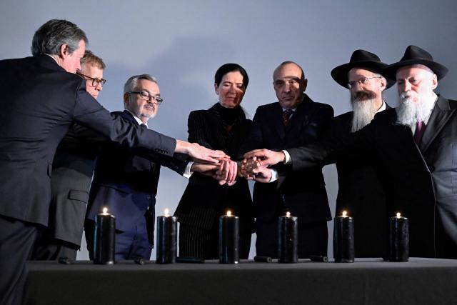 Participants, including British Ambassador to Russia Nigel Casey, Polish Ambassador to Russia Krzysztof Krajewski, Anke Holstein, adviser at the German Embassy in Russia, Israeli ambassador to Russia Oded Joseph and Chief Rabbi of Russia Berel Lazar, light candles during a ceremony marking International Holocaust Remembrance Day at the Jewish Museum and Tolerance Centre in Moscow on January 27, 2026. (Photo by Alexander NEMENOV / AFP)