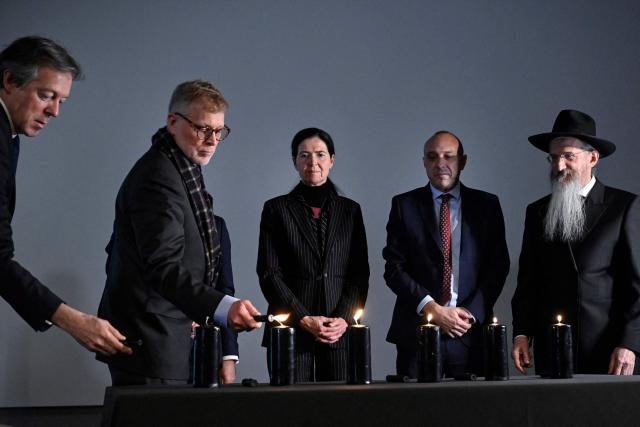Participants, including British Ambassador to Russia Nigel Casey, Polish Ambassador to Russia Krzysztof Krajewski, Anke Holstein, adviser at the German Embassy in Russia, Israeli ambassador to Russia Oded Joseph and Chief Rabbi of Russia Berel Lazar, light candles during a ceremony marking International Holocaust Remembrance Day at the Jewish Museum and Tolerance Centre in Moscow on January 27, 2026. (Photo by Alexander NEMENOV / AFP)