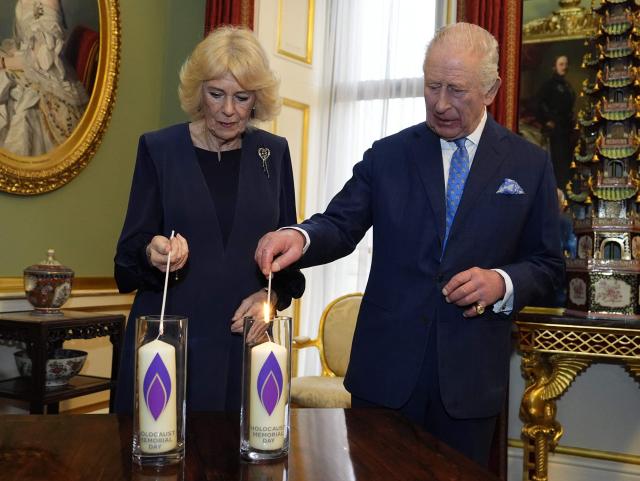 Britain's King Charles III (R) and Queen Camilla (L) light candles during a reception for survivors of the Holocaust and their families at Buckingham Palace in central London on January 27, 2026, held to mark Holocaust Memorial Day. Holocaust Memorial Day takes place every year on January 27, the anniversary of the liberation of the Auschwitz-Birkenau. The day commemorates the six million Jewish people murdered during the Holocaust, and the millions more murdered under Nazi persecution. (Photo by Aaron Chown / POOL / AFP)