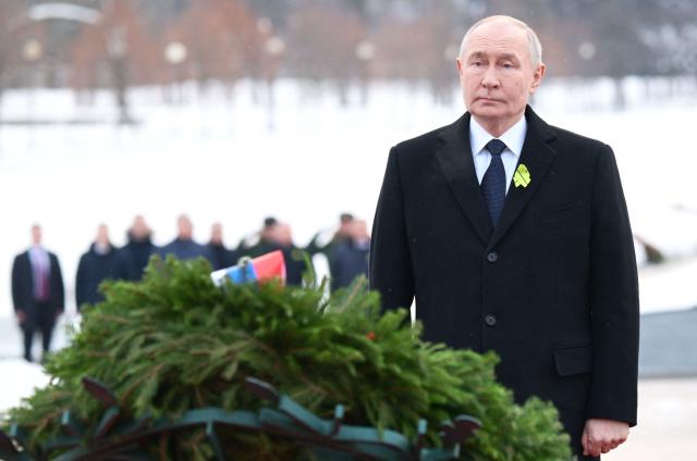 In this pool photograph distributed by the Russian state agency Sputnik, Russia's President Vladimir Putin attends a wreath-laying ceremony at the monument 'Motherland' at the Piskaryovskoye Memorial Cemetery in Saint Petersburg on January 27, 2026, marking the 82nd anniversary of the liberation of Leningrad from Nazi blockade in World War Two. (Photo by Alexei Danichev / POOL / AFP)