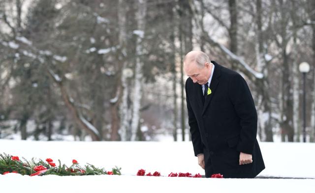 In this pool photograph distributed by the Russian state agency Sputnik, Russia's President Vladimir Putin lays flowers at the grave of his brother, who died as a child during the siege of Leningrad, during a ceremony at the Piskaryovskoye Memorial Cemetery in Saint Petersburg on January 27, 2026, marking the 82nd anniversary of the liberation of Leningrad from Nazi blockade in World War Two. (Photo by Alexei Danichev / POOL / AFP)