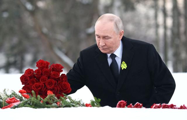 In this pool photograph distributed by the Russian state agency Sputnik, Russia's President Vladimir Putin lays flowers at the grave of his brother, who died as a child during the siege of Leningrad, during a ceremony at the Piskaryovskoye Memorial Cemetery in Saint Petersburg on January 27, 2026, marking the 82nd anniversary of the liberation of Leningrad from Nazi blockade in World War Two. (Photo by Alexei Danichev / POOL / AFP)
