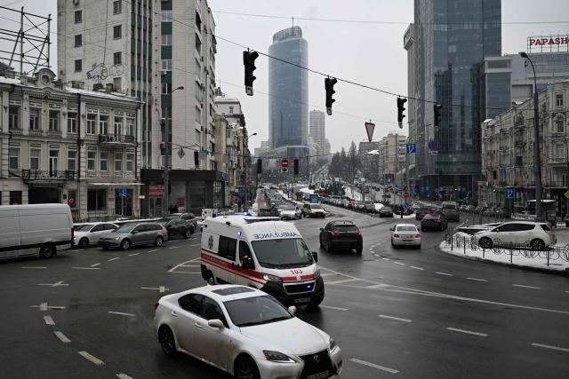 An ambulance with blue lights flashing rushes through a crossroads with non-functioning traffic lights during a power outage in Kyiv on January 27, 2026, amid the Russian invasion of Ukraine. (Photo by Sergei GAPON / AFP)