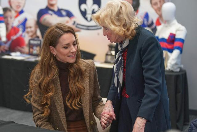 Britain's Catherine (L), Princess of Wales, holds the hand of Molly Fox (R), the wife of Wakefield Trinity legend Peter Fox, during a visit to Wakefield Trinity Rugby League club in Wakefield, northern England on January 27, 2026, to learn how their outreach programmes bring generations together and support individuals experiencing isolation in the community. (Photo by Ian Hodgson / POOL / AFP)