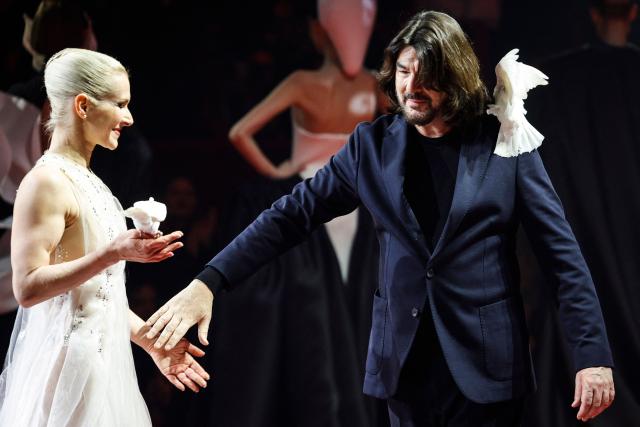 French fashion designer Stephane Rolland (R) acknowledges the audience at the end of the Stephane Rolland Women's Haute Couture Spring/Summer 2026 collection fashion show as part of the Paris Haute Couture Fashion Week, in Paris, on January 27, 2026. (Photo by GEOFFROY VAN DER HASSELT / AFP)